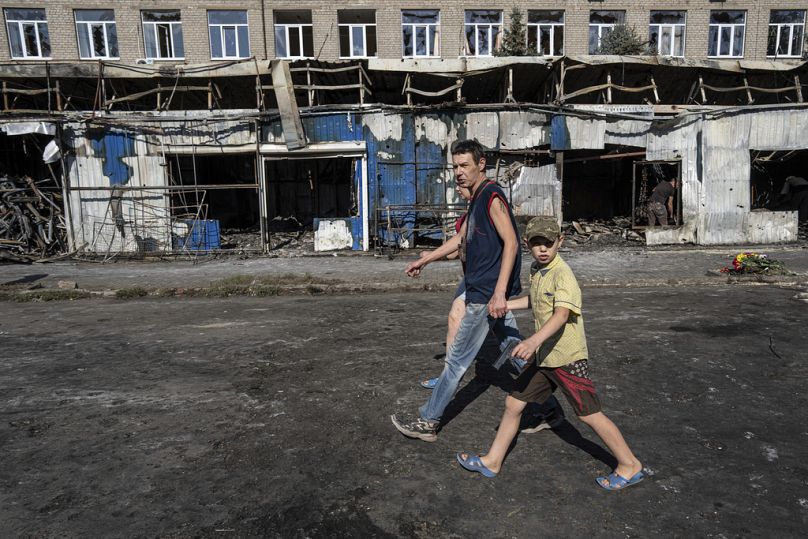 Des gens passent devant un marché détruit après l'attaque à la roquette d'hier dans le centre-ville de Kostiantynivka, en Ukraine, le jeudi 7 septembre 2023