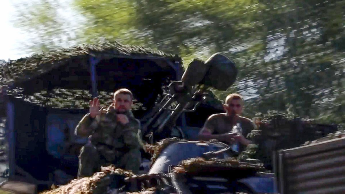 Soldiers sit in a military truck as a column of the Russian Armed Forces move to build up forces conducting active combat operations with Ukrainian formations in the Sudzhansk