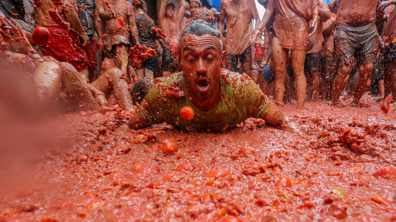 Un fêtard se repose dans une mare de tomates écrasées pendant la fête annuelle 