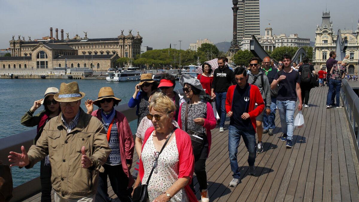 In this Wednesday, May 25, 2016 photo, tourists walk at the Maremagnum Port in Barcelona, Spain