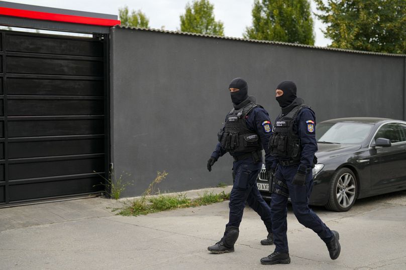 Des gendarmes patrouillent devant la résidence de la personnalité des médias sociaux Andrew Tate lors d'une opération de recherche matinale, dans la banlieue de Bucarest, en Roumanie, le 21 août 2024