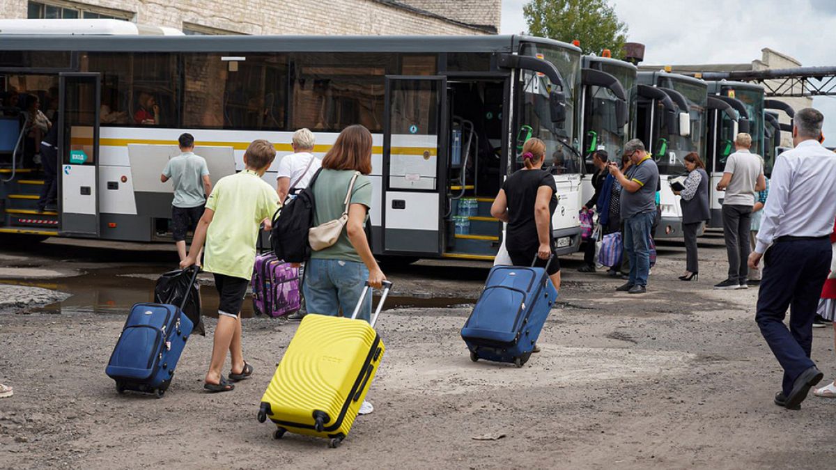 On Friday, Aug. 9, 2024, relatives carry suitcases of their children from the Kursk region helping them to leave to the Moscow region of Russia.