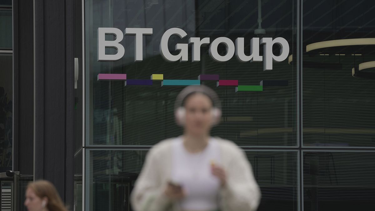 A woman walks in front of the BT headquarters, in London, Thursday, May 18, 2023.