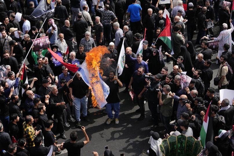 Des Iraniens brûlent une représentation du drapeau israélien lors de la cérémonie funéraire du chef du Hamas Ismail Haniyeh et de son garde du corps jeudi