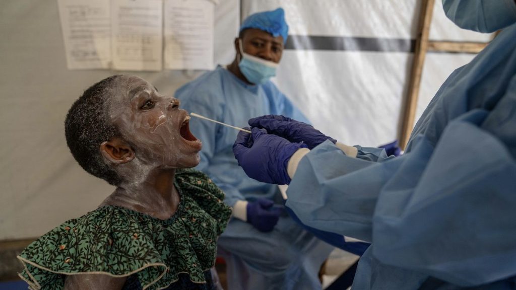 A health worker takes a saliva sample from Lucie Habimana, 13, a mpox patient, at a treatment centre in Munigi, eastern Congo, Friday, August 16, 2024.