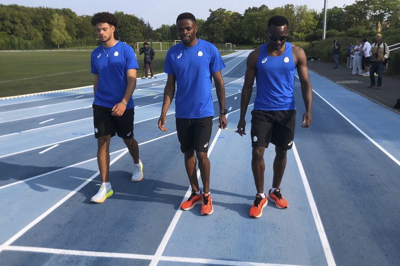 Donard Ndim Nyamjua, au centre, guide du sprinter Guillaume Junior Atangana, à droite, membre de l'équipe paralympique des réfugiés, arrive pour une séance d'entraînement au camp d'entraînement. 