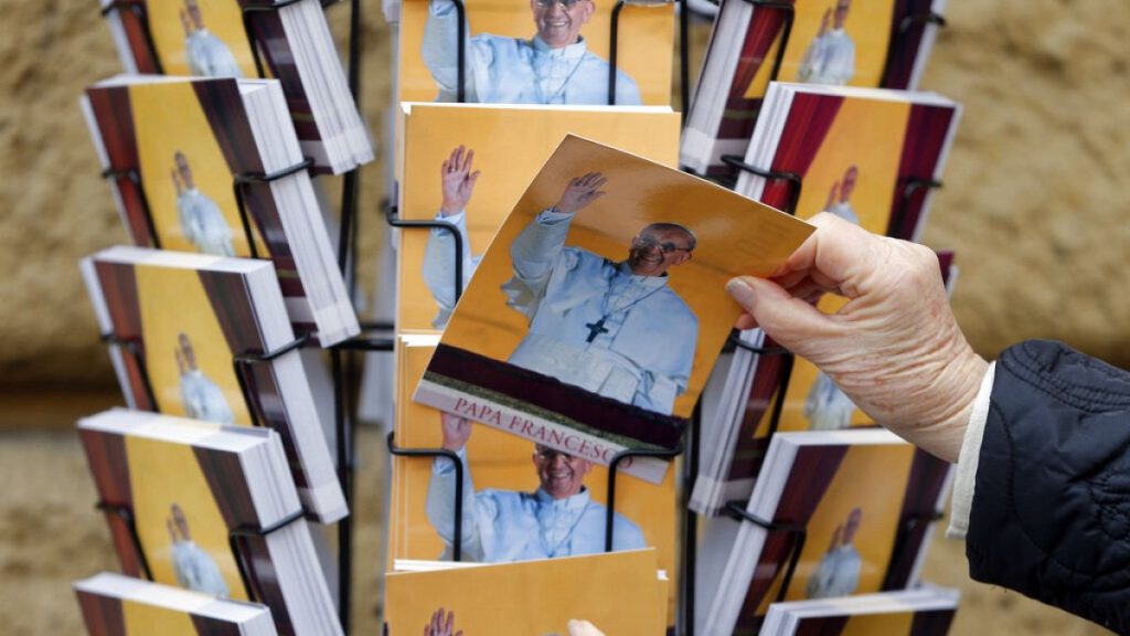 People buy postcards depicting Pope Francis in Rome, Friday, March 15, 2013.