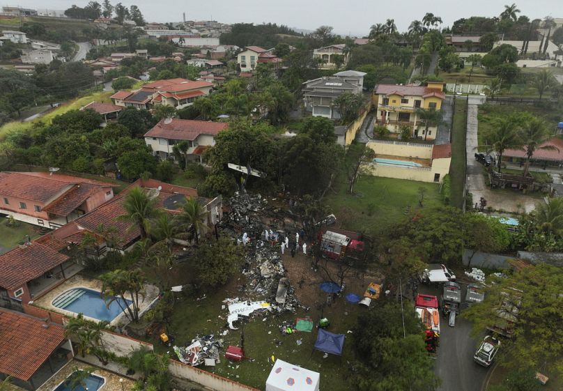 Des pompiers et des équipes de secours travaillent sur le site d'un quartier résidentiel où un avion avec 62 personnes à bord s'est écrasé à Vinhedo, dans l'État de Sao Paulo, au Brésil