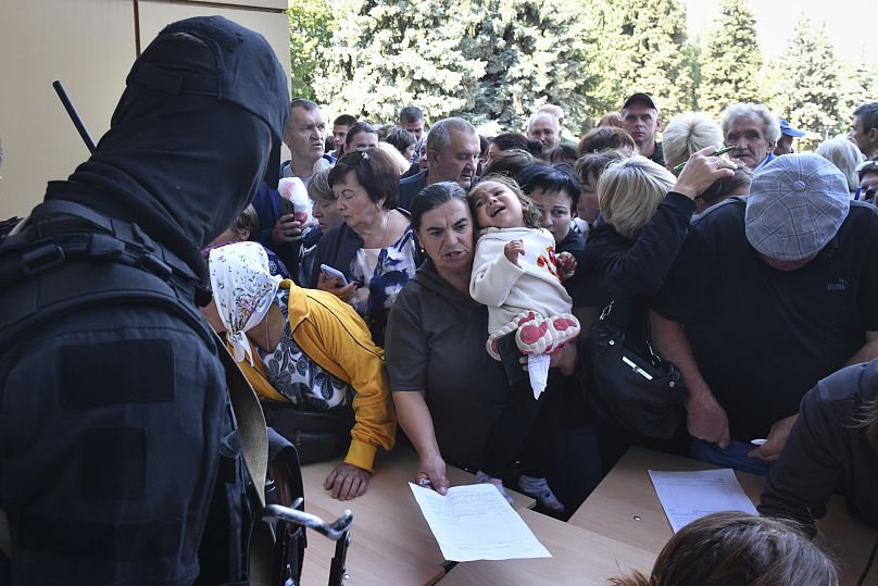 Les personnes évacuées dans la région de Koursk font la queue pour remplir le formulaire d'aide humanitaire dans un centre de distribution d'aide humanitaire à Koursk.