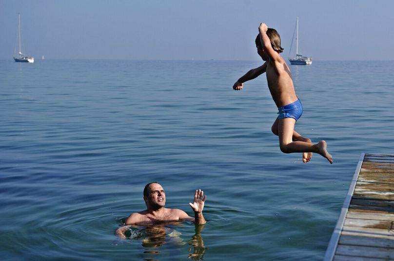 Carsten Vammen et Sebastian profitent du temps chaud à la plage de Bellevue au nord de Copenhague le samedi 1er octobre 2011.