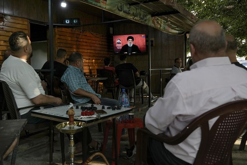 Des gens écoutent un discours du chef du Hezbollah, Sayyed Hassan Nasrallah, dans un café de Beyrouth, le 25 août 2024