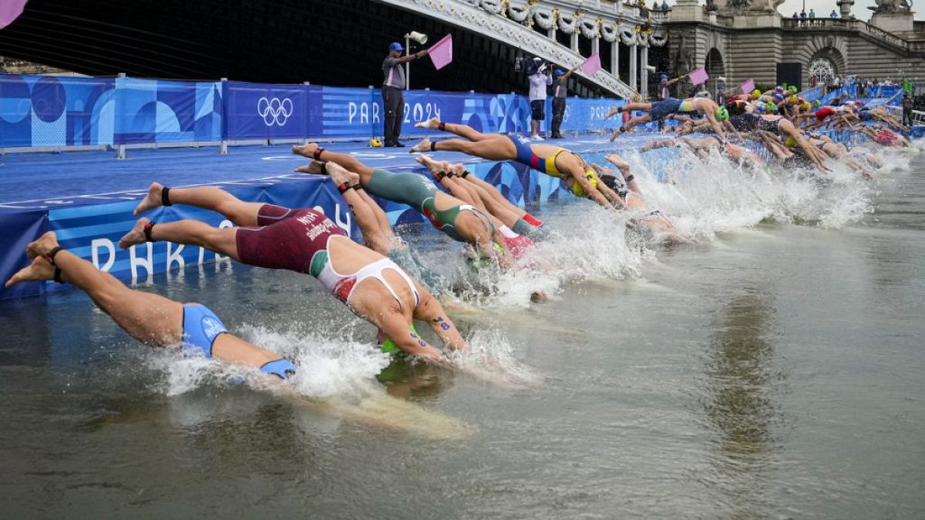 Athletes dive into the water for the start of the women