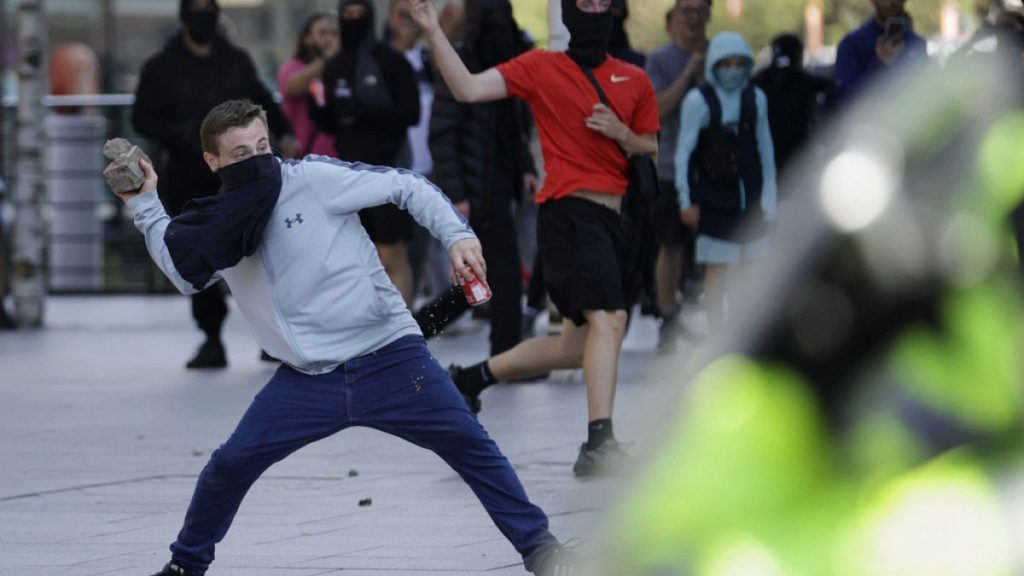 A demonstrator throws a brick during a protest in Liverpool, England, on Saturday, Aug. 3, 2024, following Monday