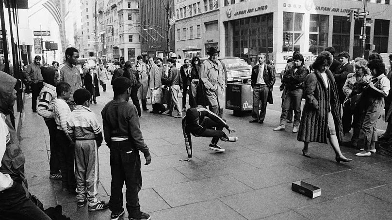 Des enfants pratiquant le breakdance se produisent le long de la Cinquième Avenue et de la 52e Rue près de la cathédrale Saint-Patrick à New York le 20 mars 1984