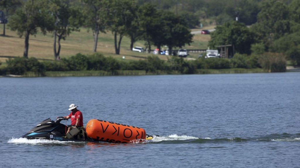 A jet ski pulls in buoys from the CrossFit Games at Marine Creek Lake, where an athlete drowned during the run swim event on Thursday, Aug. 8, 2024 in Fort Worth, Texas