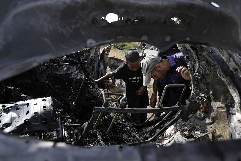 Des Palestiniens inspectent la voiture détruite qui transportait prétendument cinq militants palestiniens au nord de la ville de Tulkarem en Cisjordanie.