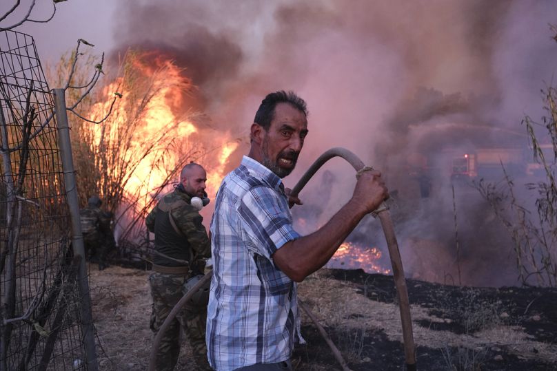 Des volontaires tentent d'éteindre l'incendie dans le nord d'Athènes, le lundi 12 août 2024, alors que des centaines de pompiers s'attaquent à un incendie de forêt majeur qui fait rage hors de contrôle.