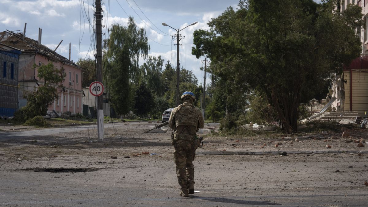 A Ukrainian soldier walks past at a city centre in Sudzha, Kursk region, Russia, Friday, Aug. 16, 2024.