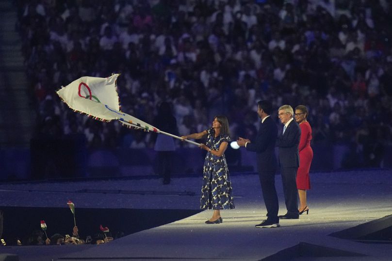 La maire de Paris Anne Hidalgo agite le drapeau olympique lors de la cérémonie de clôture des Jeux olympiques d'été de 2024 au Stade de France, dimanche 11 août 2024, à Saint-Denis, France.