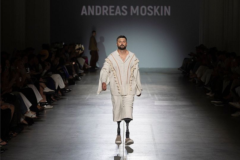 Un vétéran de guerre ukrainien portant une prothèse défile pour présenter une tenue des créateurs Andreas Moskin et Andriy Bilous lors du défilé de la Fashion Week de Kiev. 