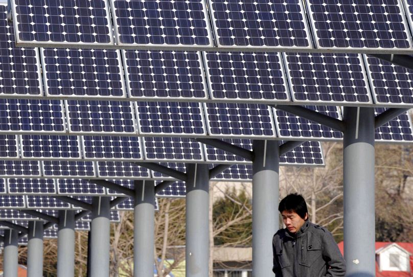 Un homme passe devant une centrale solaire à Shenyang, dans la province du Liaoning, au nord-est de la Chine, en décembre 2009.