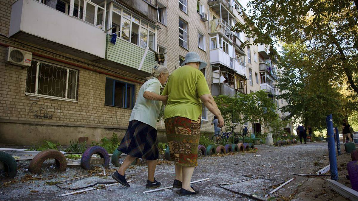 Local women walk near a residential building which was damaged by a Russian strike in Pavlohrad, September 6, 2024