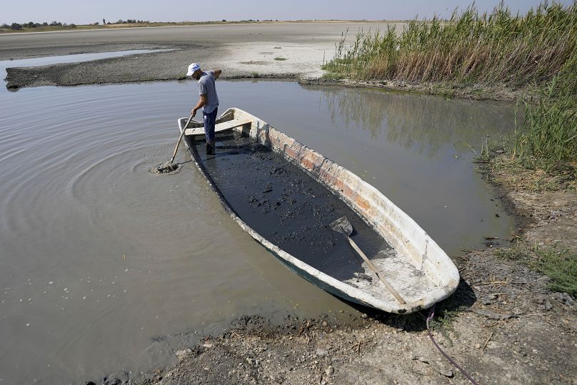 Un homme recueille de la boue destinée à être utilisée dans le cadre d'une thérapie médicale dans le lac salé de Rusanda, complètement asséché, près de Melenci, en Serbie.