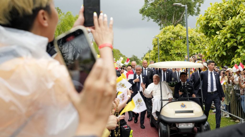 Pope Francis travels in a buggy as he greets the volunteers on his arrival in Singapore, Wednesday, Sept. 11, 2024.