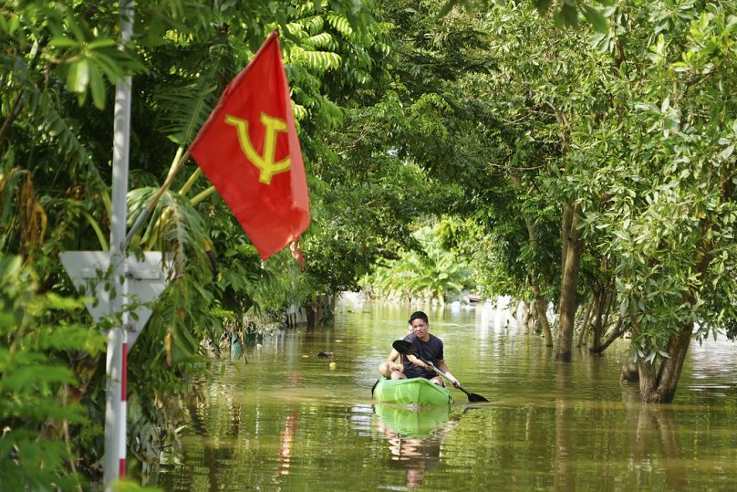 Un homme pagaie sur un bateau dans les inondations suite au passage du typhon Yagi dans le village d'An Lac, à Hanoi, au Vietnam, le vendredi 13 septembre 2024.