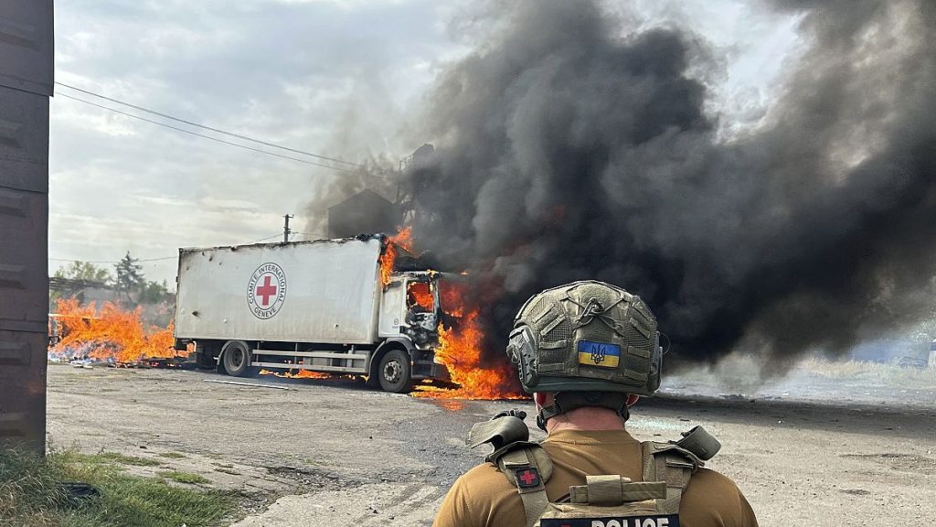 A police officer looks at a burning Red Cross vehicle that was destroyed in a Russian strike in Donetsk, September 12, 2024