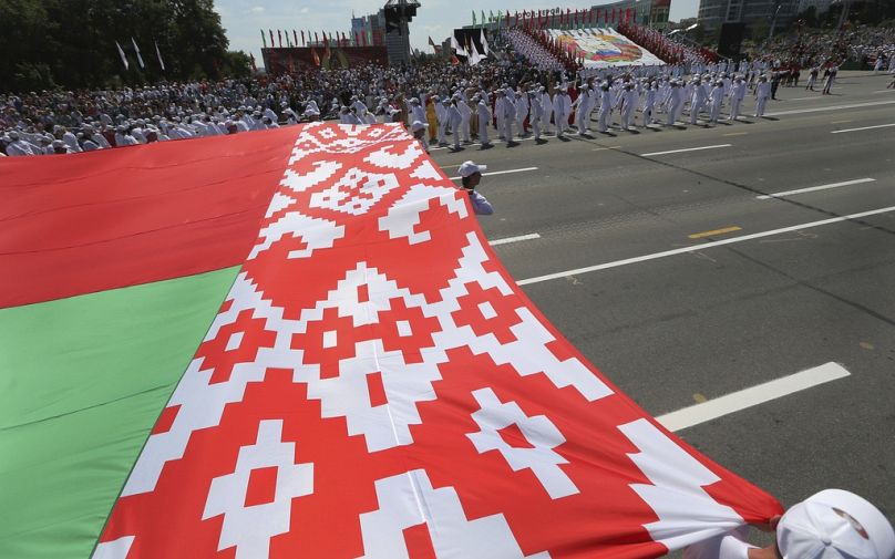 Des athlètes biélorusses portent le drapeau du pays lors des célébrations marquant le Jour de l'Indépendance à Minsk, en Biélorussie, le 3 juillet 2013. 