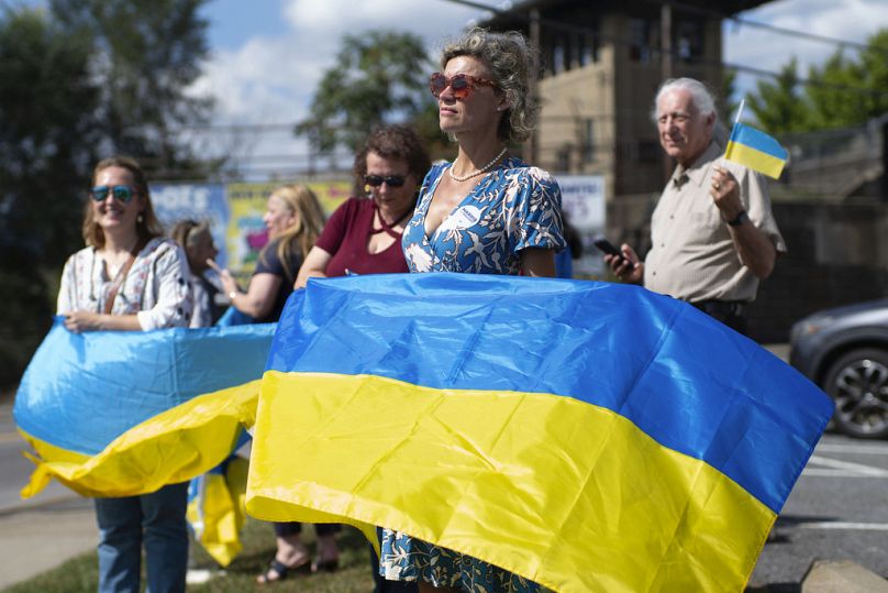 Kristina Ramanauskas agite un drapeau ukrainien avant l'arrivée du cortège du président ukrainien Volodymyr Zelenskyy à l'usine de munitions de l'armée de Scranton, le dimanche 22 septembre 2024.