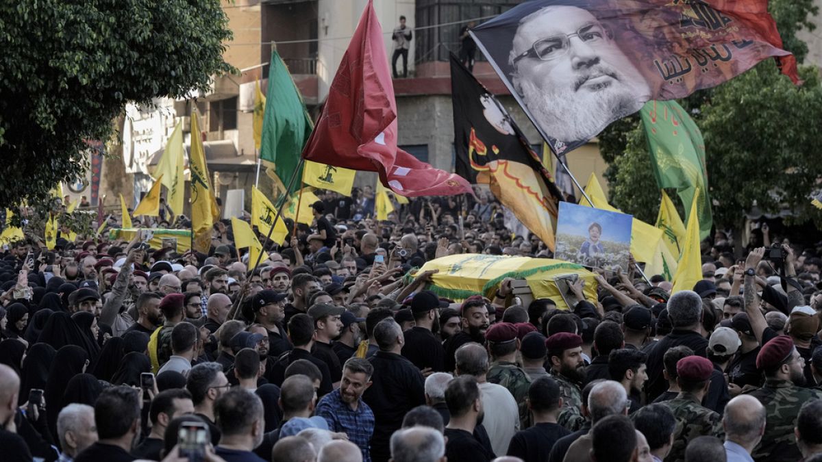 Mourners carry the coffins of Hezbollah fighters who were killed in Friday