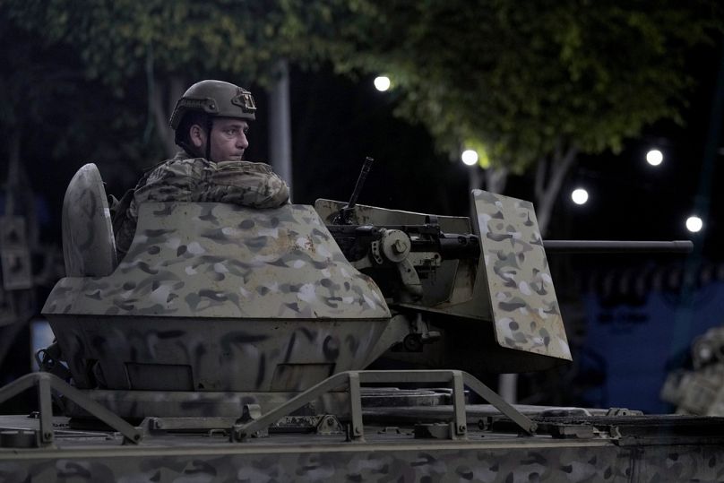 Un soldat libanais est assis au sommet d'un véhicule blindé de transport de troupes sur le site d'une frappe aérienne israélienne dans la banlieue sud de Beyrouth, le lundi 23 septembre 2024.