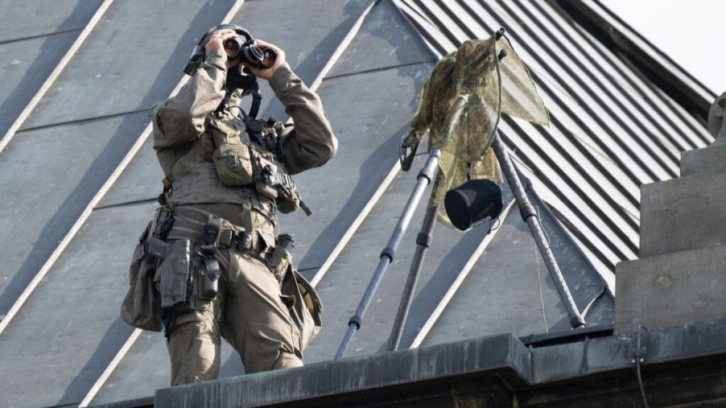 A police sniper stands on the building of the Dresden Higher Regional Court during a Social Democratic Party election campaign event attended by Chancellor Olaf Scholz.