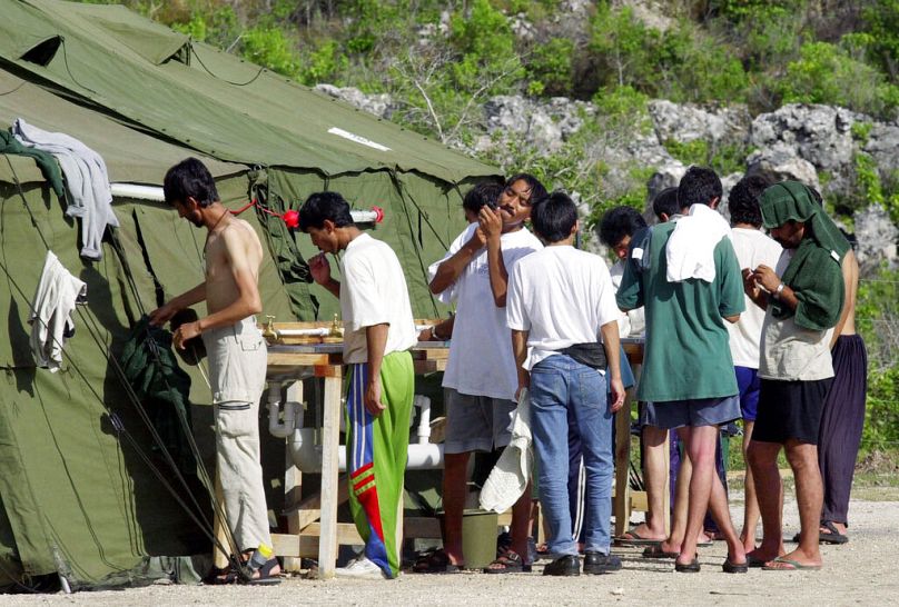 FILE - Men shave, brush their teeth and prepare for the day at a refugee camp on the Island of Nauru on 21 September, 2001.