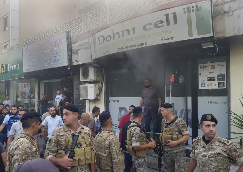 Des soldats libanais se rassemblent devant un magasin mobile endommagé après ce qui semble être le résultat de l'explosion d'un talkie-walkie à l'intérieur, dans la ville portuaire de Sidon, Leba, dans le sud du pays.