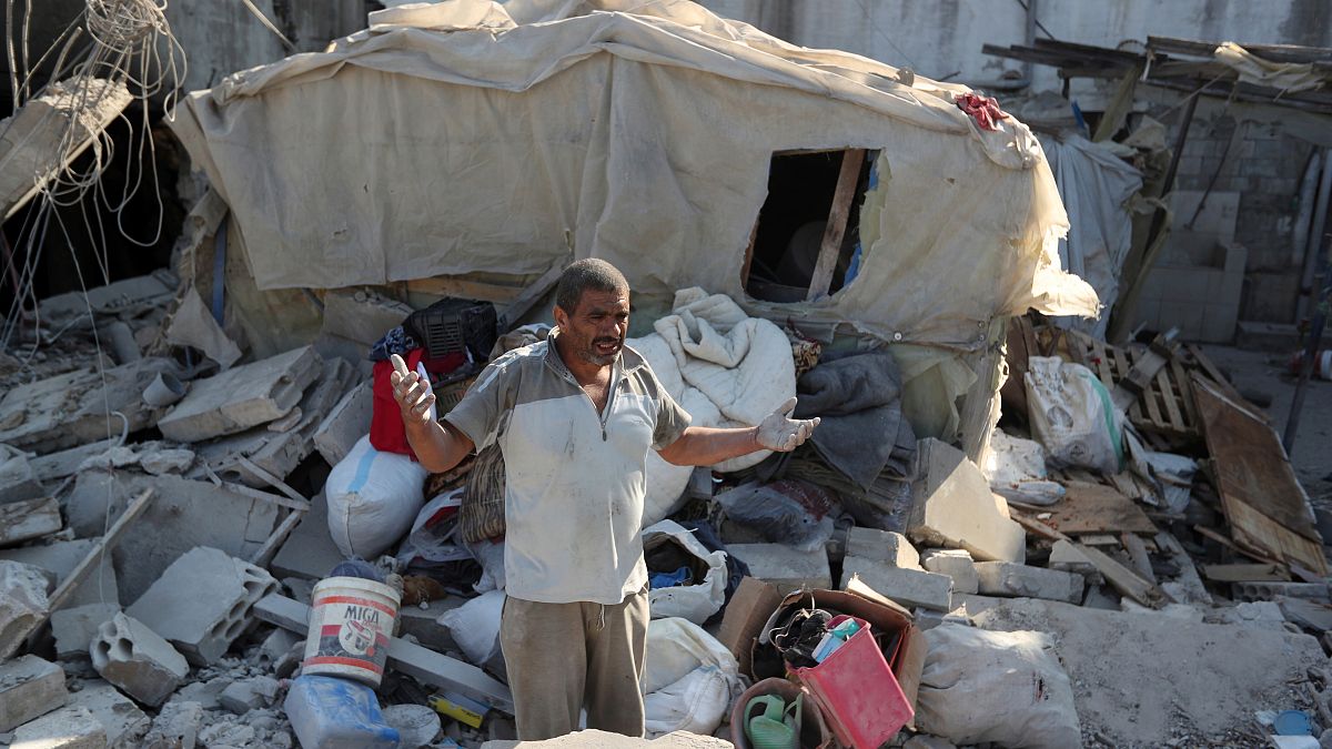 A man reacts as he stands on the rubble of a building hit in an Israeli airstrike in the southern Lebanese village of Akbieh..