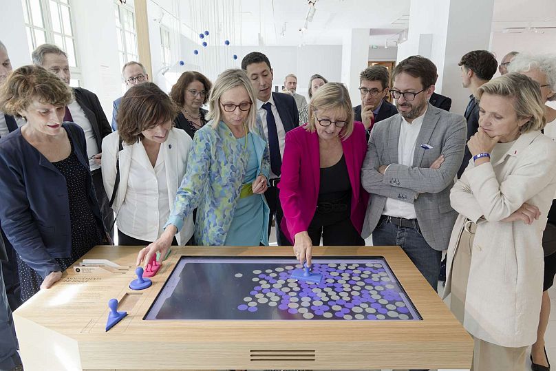 Directrice de l'Institut Henri Poincaré Sylvie Benzoni (en bleu) et d'autres démontrant la simulation de mouvement de foule à la Maison Poincaré.