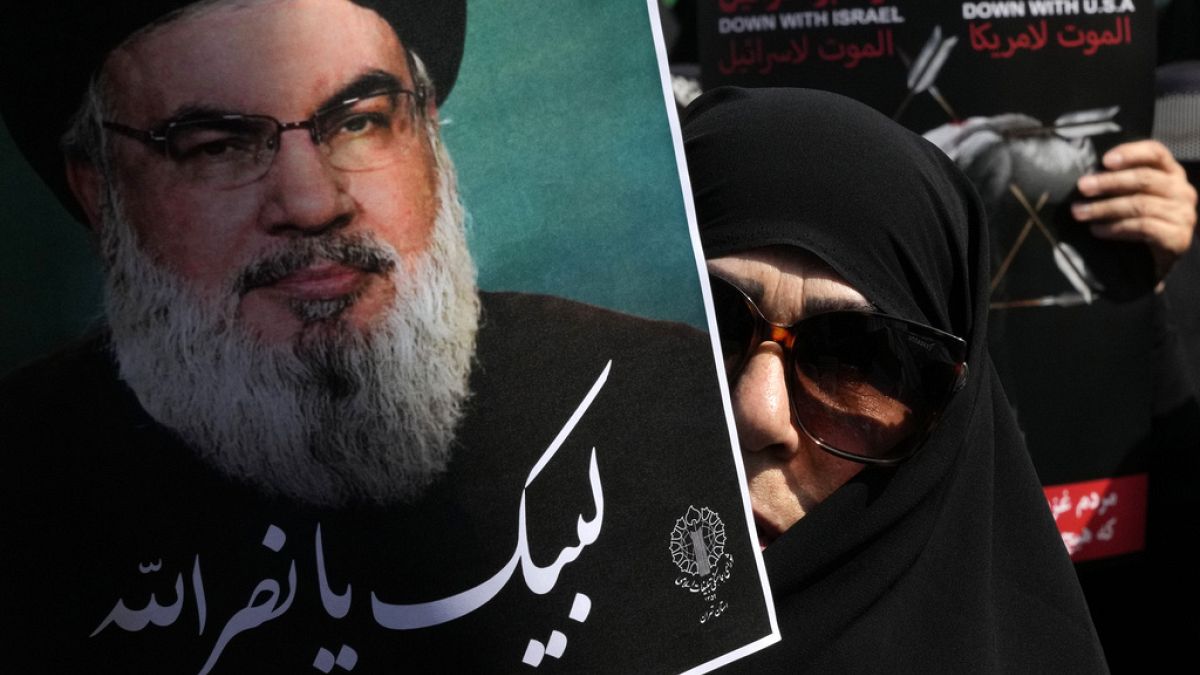 An Iranian worshipper holds up a poster of Hezbollah leader Sayyed Hassan Nasrallah, September 27th 2024