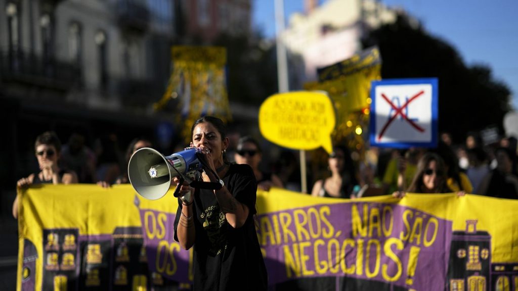 Activists carry a banner saying "Our neighbourhoods are not your businesses" during a protest against Portugal