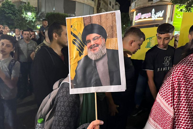 Des manifestants palestiniens brandissent des drapeaux du Hezbollah et des affiches de Hassan Nasrallah lors d'un rassemblement de soutien au Hezbollah à Ramallah, le 28 septembre 2024.