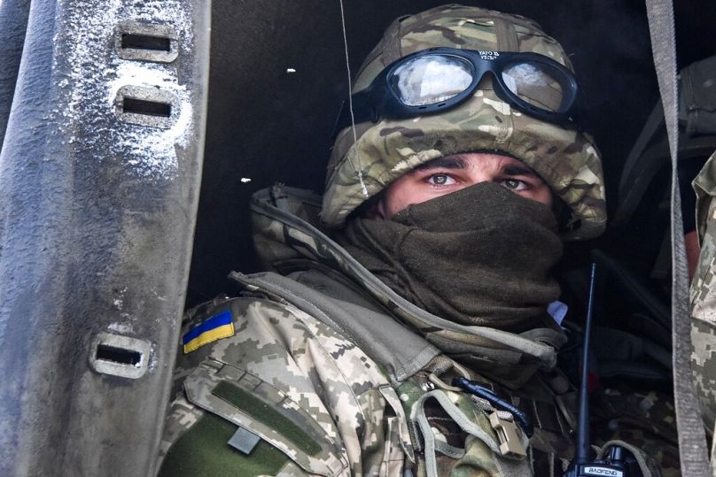 Un soldat ukrainien regarde depuis un camion militaire les rebelles pro-russes lors de la rotation militaire ukrainienne à l'aéroport de Donetsk, dans l'est de l'Ukraine, le 6 janvier 2015. 