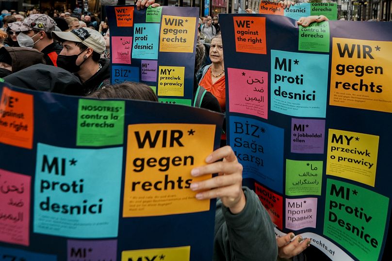 Les gens tiennent des banderoles multilingues sur lesquelles on peut lire "Nous sommes contre la droite," avant le dernier rassemblement électoral du Parti de la Liberté à Vienne, le 27 septembre 2024