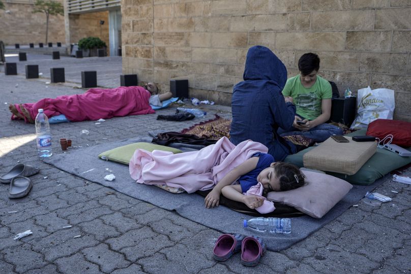 Une famille dort par terre dans le quartier de la corniche de Beyrouth après avoir fui les frappes aériennes israéliennes dans la banlieue sud de Dahiyeh, le dimanche 29 septembre 2024. 