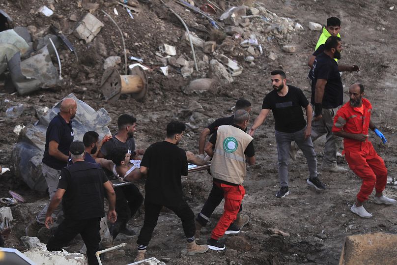 Les équipes de secours transportent un homme blessé depuis deux bâtiments adjacents touchés par une frappe aérienne israélienne à Sidon, le 29 septembre 2024.