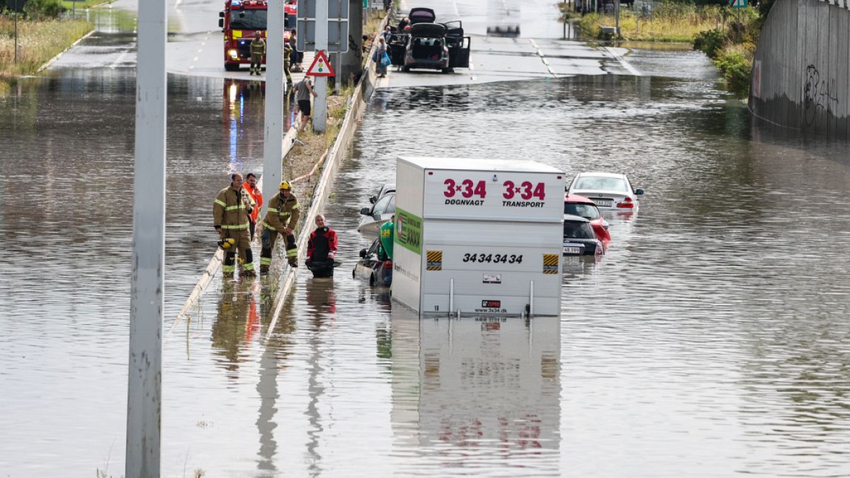 Firefighters work at a flooded road in Copenhagen, Sunday, Aug. 4, 2024.