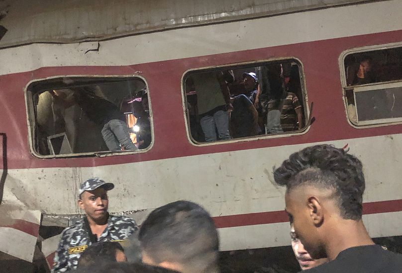 Des personnes entourent deux trains de voyageurs qui sont entrés en collision dans la ville de Zagazig, dans le delta du Nil en Égypte, le 14 septembre 2024