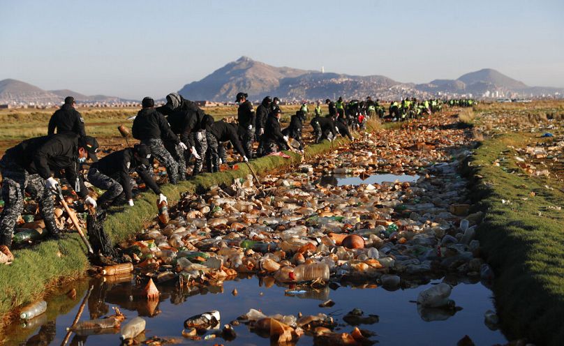 Des policiers s'efforcent de retirer les déchets de la rivière Tagaret polluée qui se jette dans le lac Uru Uru, près d'Oruro, en Bolivie