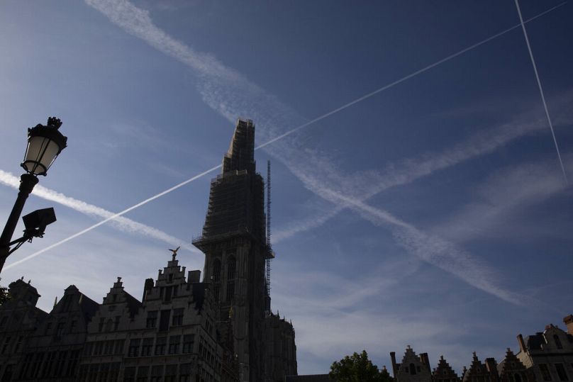 Les bâtiments de la place principale de la vieille ville se découpent sur un ciel avec des traînées d'avion à Anvers, en Belgique.